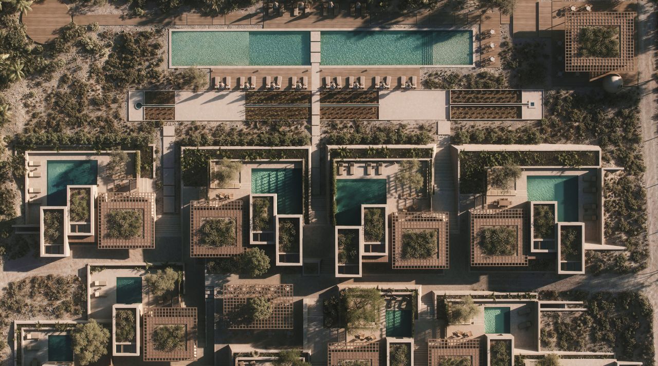 Aerial view of the Andros resort: villas with private pools and pergola courtyards set among scrub and olive trees