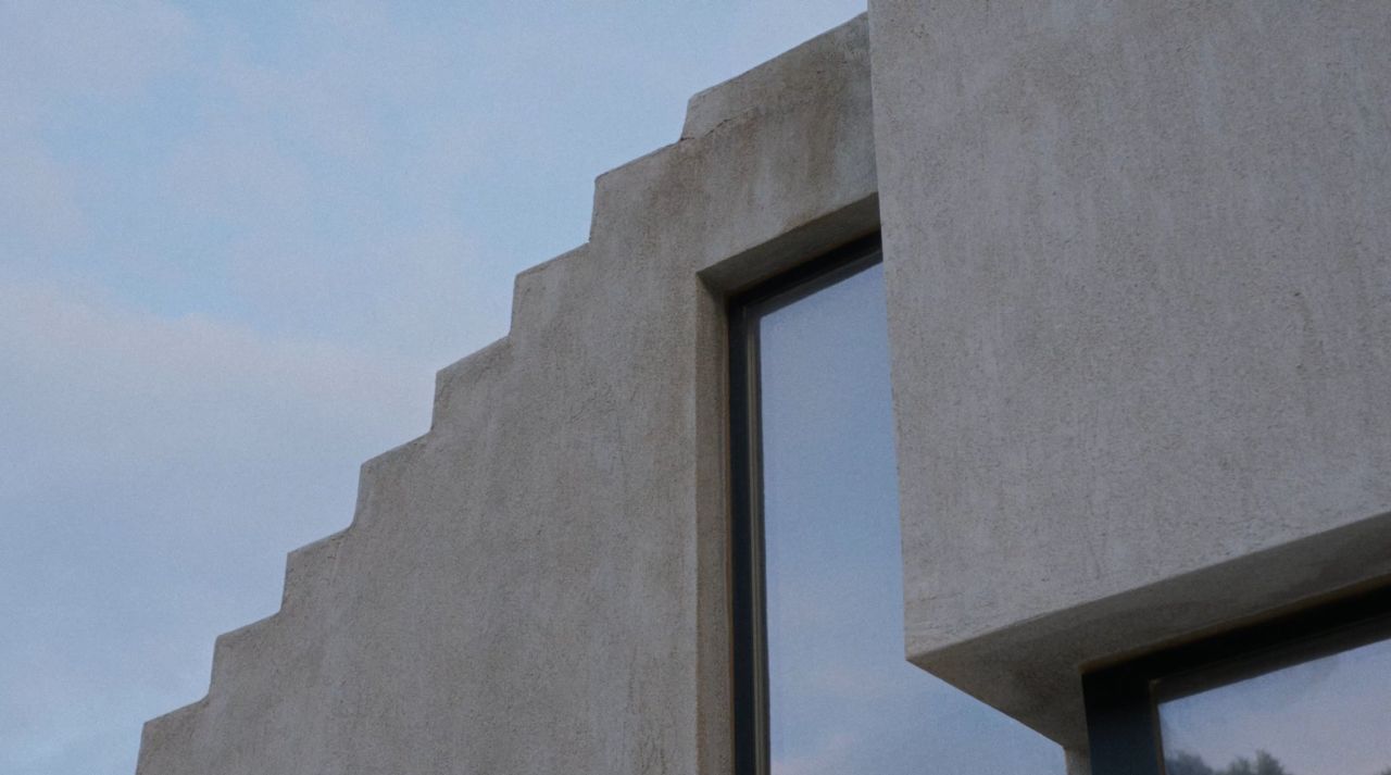 A Touch of New: stepped concrete wall beside a deep-set window against a pale sky