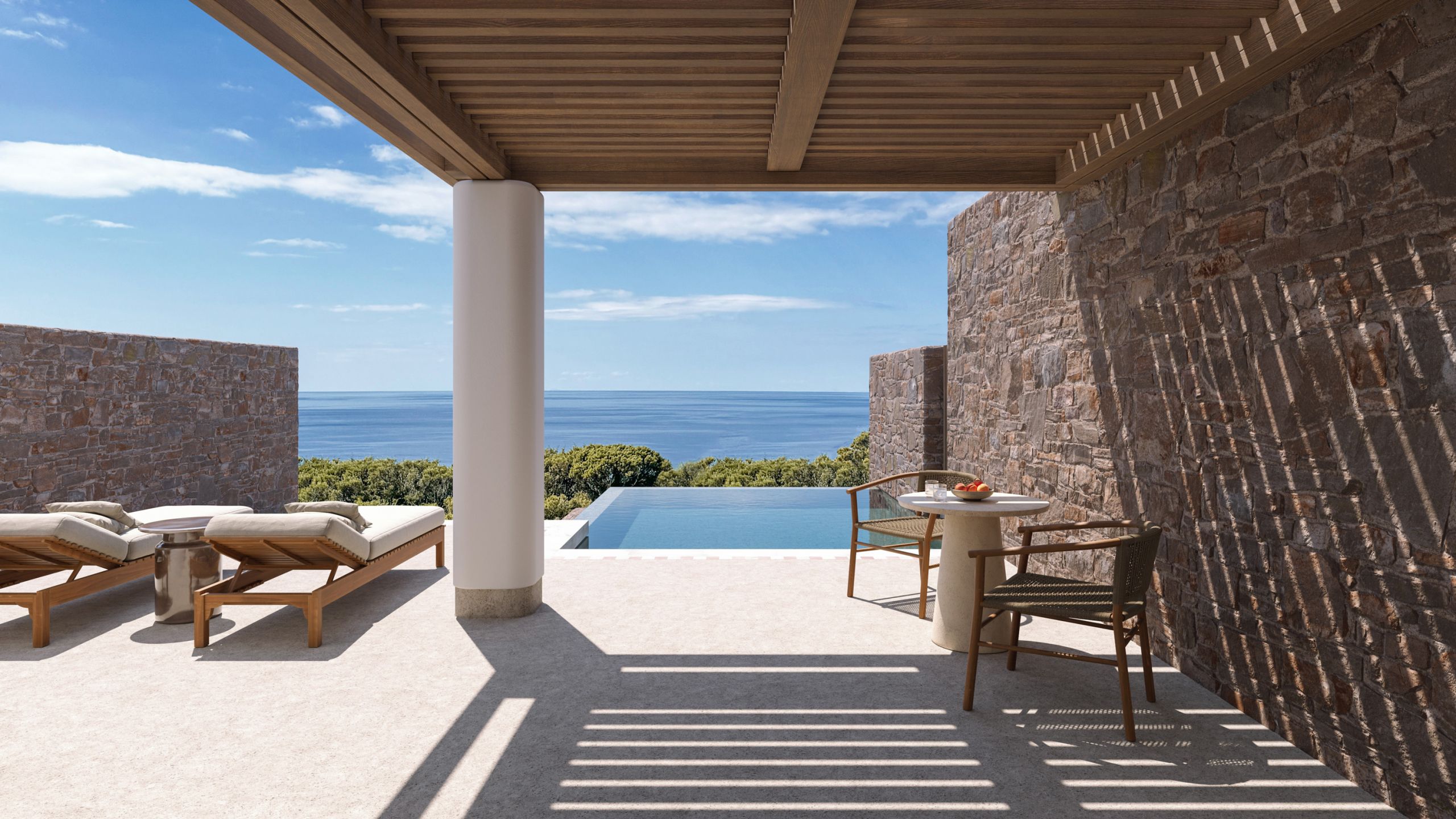 Shaded suite terrace with a timber pergola, a stone wall, loungers and a plunge pool facing the sea