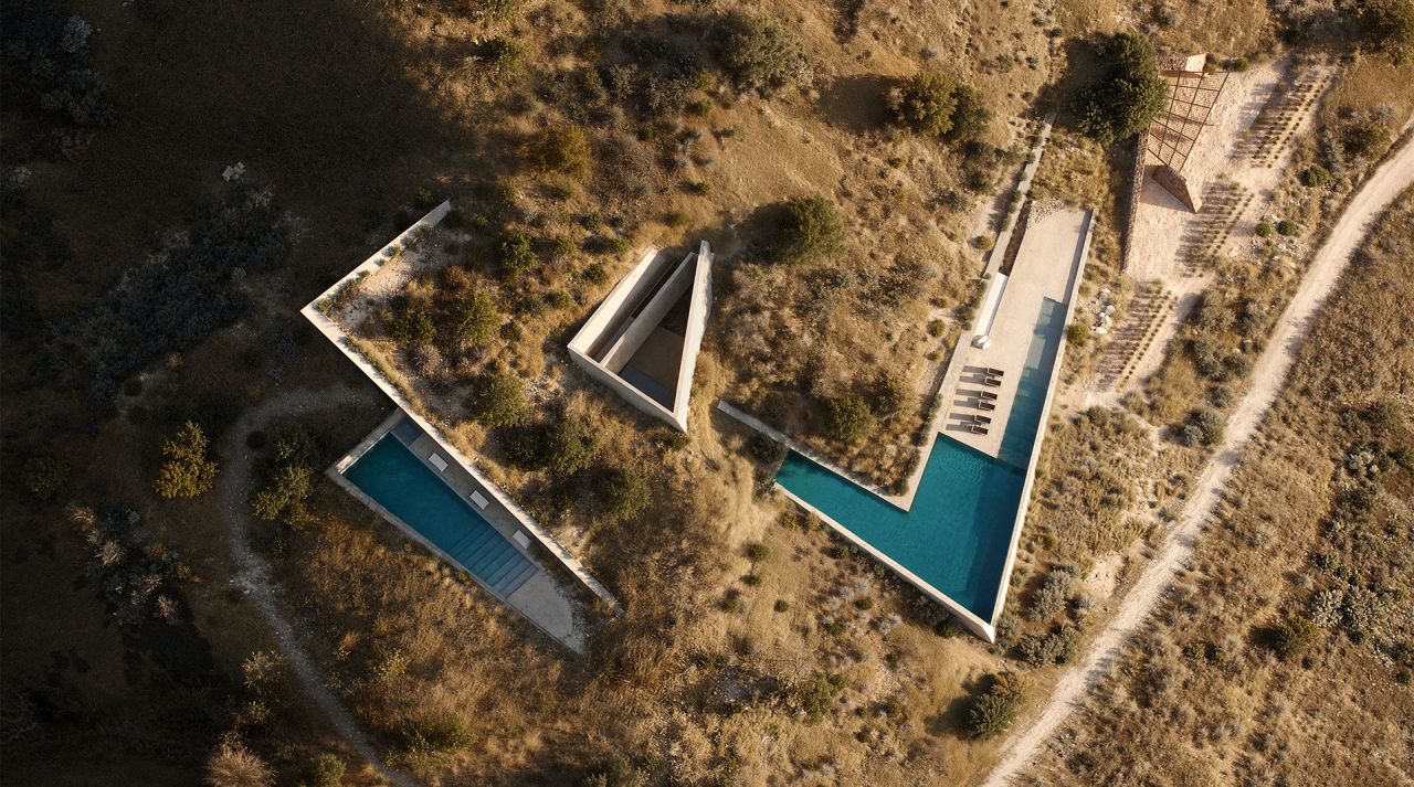 Rendering of Terra Fracta from directly above, angular concrete pools and a pavilion set into a dry hillside on Antiparos